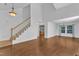 Bright living room with staircase features hardwood flooring, and an open layout to dining and kitchen areas at 1323 Fairmont St, Durham, NC 27713