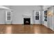 Open-concept living room with hardwood floors, fireplace, and multiple windows at 1323 Fairmont St, Durham, NC 27713