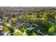 An aerial view shows multiple homes in a neighborhood surrounded by lush green trees at 1325 George Bason Rd, Graham, NC 27253