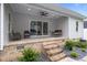 Covered back porch featuring a ceiling fan, porch swing, and comfortable seating, overlooking a landscaped yard at 1325 George Bason Rd, Graham, NC 27253