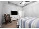 Bedroom with a rocking chair, television, a bed with striped bedding, and neutral-toned walls at 1325 George Bason Rd, Graham, NC 27253