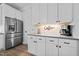 Modern kitchen with white cabinets, stainless steel refrigerator, and coffee station at 1325 George Bason Rd, Graham, NC 27253