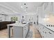 Open kitchen with white cabinets, island with seating, and stainless appliances at 1325 George Bason Rd, Graham, NC 27253