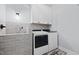 Laundry room featuring white cabinets, gray tile backsplash, and modern washing machine and dryer at 1325 George Bason Rd, Graham, NC 27253