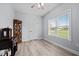 Bright office featuring a window with blinds, wood-look floors, and a decorative cabinet at 1325 George Bason Rd, Graham, NC 27253