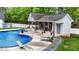 A luxurious in-ground pool with a spacious patio, cabana, and lush landscaping for ultimate relaxation at 1325 George Bason Rd, Graham, NC 27253
