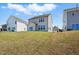 Back exterior of home with a grassy yard and other houses nearby at 135 Carlton Ln, Franklinton, NC 27525