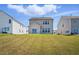 A rear view of the house, with a grassy yard and other houses nearby at 135 Carlton Ln, Franklinton, NC 27525