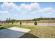 View of backyard featuring concrete patio overlooking grass and green trees in the distance at 135 Carlton Ln, Franklinton, NC 27525