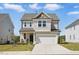 Charming two-story home featuring attached garage, inviting front porch, and manicured lawn at 135 Carlton Ln, Franklinton, NC 27525