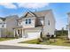 Side view of a well-maintained two-story home with neutral siding and a two-car attached garage at 135 Carlton Ln, Franklinton, NC 27525