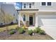 Inviting front porch with rocking chairs, landscaping, and a black front door at 1227 at 135 Carlton Ln, Franklinton, NC 27525
