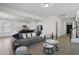Open living space with gray sofa, white walls, and a view into the modern kitchen at 135 Carlton Ln, Franklinton, NC 27525