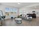 Bright living room with large windows, gray sofa, stylish tables, and open layout to kitchen at 135 Carlton Ln, Franklinton, NC 27525