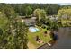 Gorgeous aerial view of a home with a balcony, fenced in pool, lush lawn, and a private dock on the lake at 1422 Gormly Cir, Sanford, NC 27330