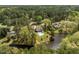 Aerial view of a lakefront home with a pool, balcony, lush landscaping and a private dock on the lake at 1422 Gormly Cir, Sanford, NC 27330