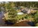 A captivating aerial view of an estate on a lake with a pool, manicured lawn, and mature trees at 1422 Gormly Cir, Sanford, NC 27330