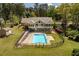 Expansive backyard featuring an in-ground pool, lush lawn, patio area, and mature trees at 1422 Gormly Cir, Sanford, NC 27330