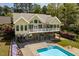 A view of the home's back exterior, a blue pool, patio, and beautiful flowerbeds at 1422 Gormly Cir, Sanford, NC 27330