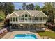 A view of the home's back exterior, blue pool, and relaxing hot tub at 1422 Gormly Cir, Sanford, NC 27330