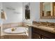 Bright bathroom features a soaking tub and a granite countertop vanity near a window with lots of natural light at 1422 Gormly Cir, Sanford, NC 27330