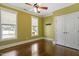 Well-lit bedroom boasts hardwood floors, a ceiling fan, two windows and a closet with white doors at 1422 Gormly Cir, Sanford, NC 27330