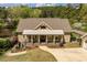 Well manicured landscaping and covered porch provide curb appeal to this tan home with lake views at 1422 Gormly Cir, Sanford, NC 27330