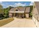 The front of the house has a charming covered porch with stone columns, lush landscaping, and a circular driveway at 1422 Gormly Cir, Sanford, NC 27330