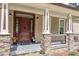 Inviting front porch with stone accents, decorative columns, and a stylish front door at 1422 Gormly Cir, Sanford, NC 27330