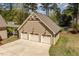 Aerial view of a three-car garage with cream doors and siding and well-maintained landscaping at 1422 Gormly Cir, Sanford, NC 27330