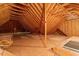 An unfinished attic space with exposed wooden beams, insulation, and a plywood floor at 1537 Heritage Club Ave, Wake Forest, NC 27587