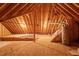 Spacious unfinished attic featuring insulation, plywood floors, and a water heater at 1537 Heritage Club Ave, Wake Forest, NC 27587
