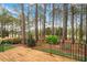 A wood deck overlooking a backyard with mature trees, lush lawn and landscaping at 1537 Heritage Club Ave, Wake Forest, NC 27587