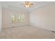 Spacious bedroom featuring neutral carpet, a tray ceiling, and a large window at 1537 Heritage Club Ave, Wake Forest, NC 27587