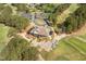 Aerial view highlighting a clubhouse with a wraparound porch and manicured landscaping, set against a lush green golf course at 1537 Heritage Club Ave, Wake Forest, NC 27587