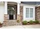 Stone accented front entrance with a black front door and sidelight windows at 1537 Heritage Club Ave, Wake Forest, NC 27587