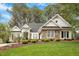 Charming home with a stone facade, manicured lawn and mature trees at 1537 Heritage Club Ave, Wake Forest, NC 27587