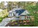 Charming white home featuring stone accents, manicured landscaping, and a long driveway at 1537 Heritage Club Ave, Wake Forest, NC 27587