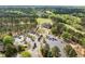 Aerial view featuring a golf course and clubhouse surrounded by lush trees and a full parking lot at 1537 Heritage Club Ave, Wake Forest, NC 27587