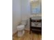 Cozy half bath with sleek vanity, mirror, and modern fixtures, complemented by warm wood-look flooring at 157 Durants Neck Ln, Morrisville, NC 27560