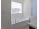 Bright bathroom featuring a soaking tub under a window for a relaxing spa-like experience at 157 Durants Neck Ln, Morrisville, NC 27560