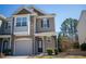 Exterior angle of a neutral two-story home featuring a stone facade, balcony, and garage at 157 Durants Neck Ln, Morrisville, NC 27560