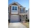 Two-story home featuring a stone facade, balcony, garage, and neutral siding at 157 Durants Neck Ln, Morrisville, NC 27560