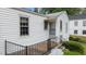 Backyard featuring porch with stairs and black railing, along with greenery at 1631 Sunset Ave, Henderson, NC 27536