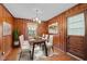 Charming dining room with wood paneling, stylish lighting, and seating for six, perfect for entertaining guests at 1631 Sunset Ave, Henderson, NC 27536