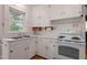 Vintage kitchen featuring white cabinets, a double sink, and a modern electric range at 1631 Sunset Ave, Henderson, NC 27536
