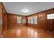 Bright and airy living room boasts original wood paneling, hardwood floors, and ample windows for plenty of natural light at 1631 Sunset Ave, Henderson, NC 27536