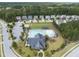 Birds eye view of a community pool with sun shelters and a clubhouse surrounded by residential homes at 1840 Flint Valley Ln, Apex, NC 27502