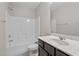 A bright bathroom with a shower-tub combo and a vanity with a dark countertop at 1840 Flint Valley Ln, Apex, NC 27502