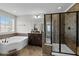 Bright bathroom featuring a soaking tub, a glass-enclosed shower, and a dark vanity with modern fixtures at 1840 Flint Valley Ln, Apex, NC 27502